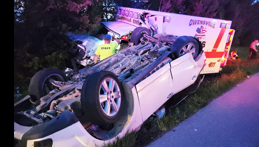 TWO PARAMEDICS crewing an Owensville Area Ambulance District rig were injured Friday evening when a car which had been rear-ended by another motorists — attempting to cut back into a line of traffic during a passing attempt — overturned and slid into their path on U.S. 50 in Osage County.